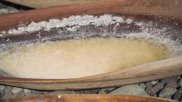 Production of sea salt in the Bali,Indonesia. Salt crystallizes out of the ground in salt farm, filled with natural salt from the sea.