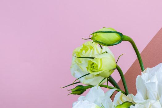 Fresh bouquet in pastel shades of pink, white, green, yellow. Homogeneous pink, blue background. Delicate bouquet for a woman.