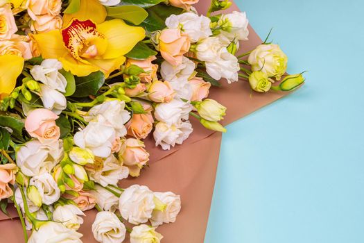 Fresh bouquet in pastel shades of pink, white, green, yellow. Homogeneous pink, blue background. Delicate bouquet for a woman.