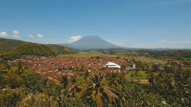 Aerial view Town near volcano Agung, rice terrace, farmlands, village, fields with crops, agricultural land of farmers. Bali, Indonesia