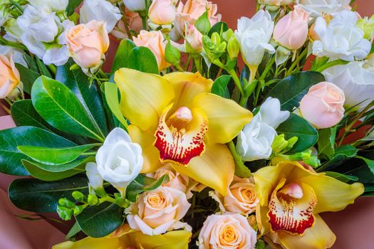 Fresh bouquet in pastel shades of pink, white, green, yellow. Homogeneous pink, blue background. Delicate bouquet for a woman.