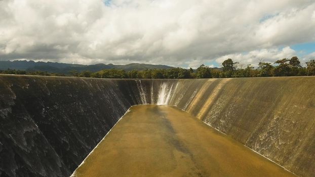 Aerial view Dam on the lake in the rainforest on the island. Water flowing from the dam, Water for Irrigation countryside. Water Cascades Over Lake Bohol island, Philippines..