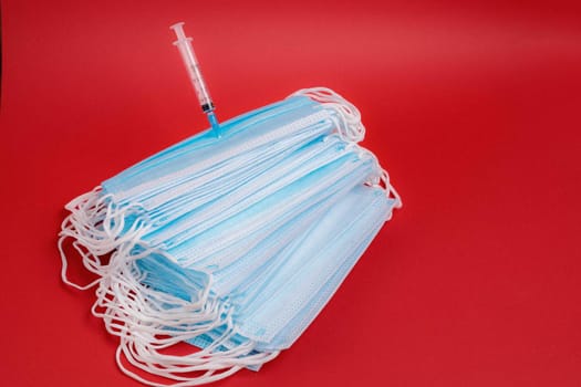On the table is a medical mask with a syringe and medicine for coronavirus. Coronavirus quarantine concept.