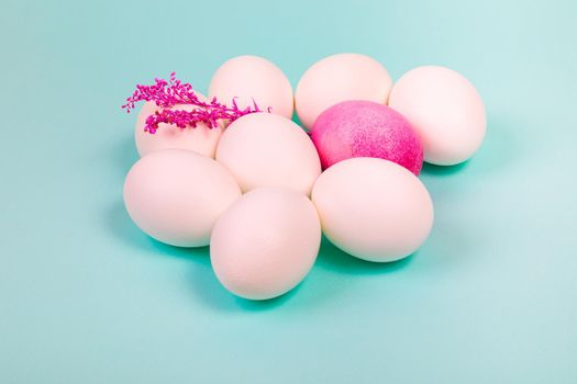 Easter. White eggs with a red egg and a twig on a uniform blue background. Place for text.