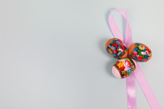 Easter. Khokhloma eggs on a uniform blue background with a ribbon. Place for text.