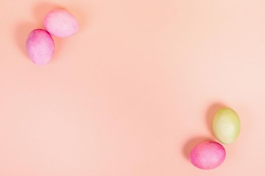 Easter. Multi-colored eggs on a uniform pink background with place for text. View from above