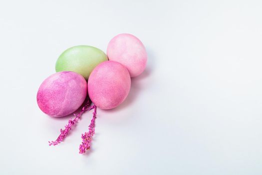 Easter. Multi-colored eggs with twigs, on a white background with a place for text. View from above