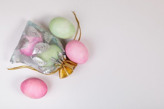 Easter. Eggs of different colors in a bag on a uniform blue background. Place for text.