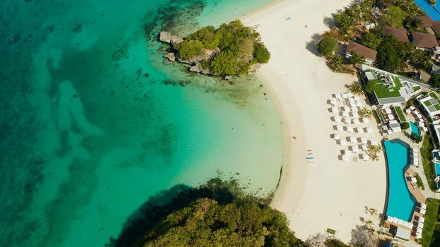 Tropical beach with luxury hotels and turquoise lagoon aerial view, Boracay, Philippines. White sandy beach with tourists and hotels. Seascape with beach on tropical island. Summer and travel vacation concept.