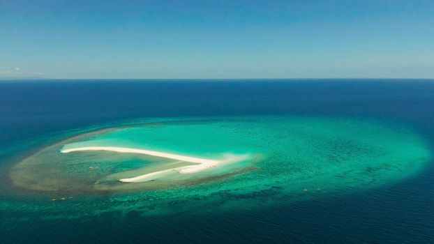 Beautiful beach on tropical island surrounded by coral reef, sandy bar with tourists, top view. Sandbar Atoll. Summer and travel vacation concept, Camiguin, Philippines.