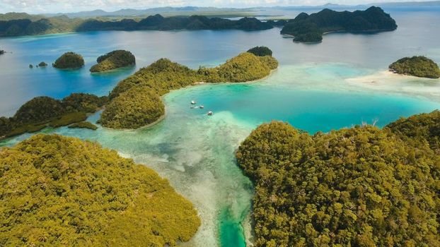Aerial view: beach, tropical island, sea bay and lagoon, Siargao. Tropical landscape hill, clouds and mountains rocks with rainforest. Azure water of lagoon. Shore Landscape Bay. Travel concept.
