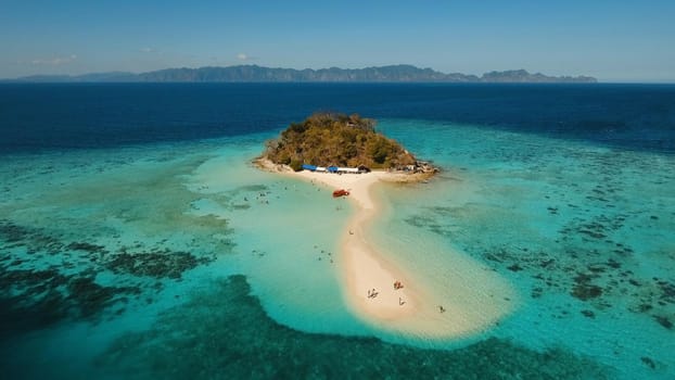 Aerial view of tropical beach on the Bulog Dos Island, Philippines. Beautiful tropical island with sand beach, palm trees. Tropical landscape: beach with palm trees. Seascape: Ocean, sky, sea. Travel concept.