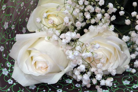 a bouquet of three white roses decorated with flowers for Valentine's day