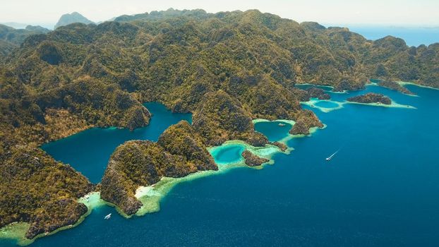 Aerial view lagoon with blue, azure water in middle small islands and rocks. Beach, tropical island, sea bay and lagoon, mountains with forest, Palawan, Coron. Busuanga. Seascape, tropical landscape. Philippines.