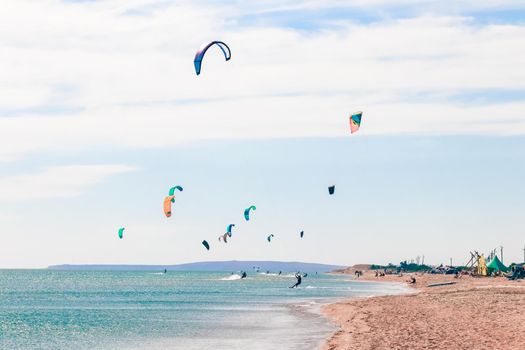 a kitesurfer surfing on the smooth azure water. recreational sport. A Man Rides A Kiteboarding In The Sea Water. extreme sport. High quality photo