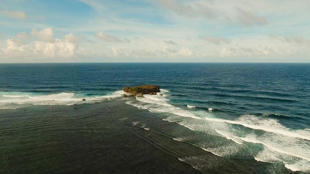 Large rock in the blue sea on a sunny day. Aerial view Rocky cliff in the ocean in the Siargao Island. Seascape: Ocean, sky, sea . Philippines.