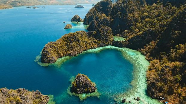 Tropical lagoon with azure water, beach by the Kayangan Lake, Philippines. Aerial view Coron island, with cove, bay at Kayangan lake. Lagoon with sailing boats. Aerial video. Philippines. Travel concept