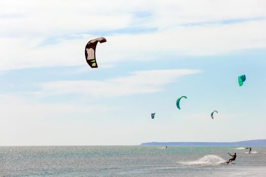 a kitesurfer surfing on the smooth azure water. recreational sport. A Man Rides A Kiteboarding In The Sea Water. extreme sport. High quality photo