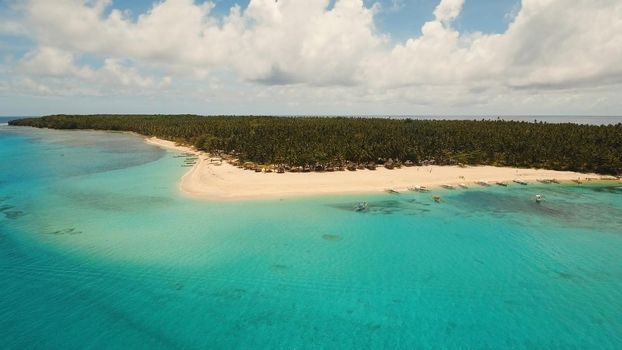 Aerial view of beautiful tropical island Daco with white sand beach. View of a nice tropical beach from the air. Beautiful sky, sea, resort. Seascape: Ocean and beautiful beach paradise. Philippines. Travel concept.