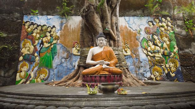 Statue of the Buddhist God Buddha in the Buddhist temple Brahma Vihara Arama with statues of the gods on Bali island, Indonesia. Bali Architecture, Ancient design. Travel concept.