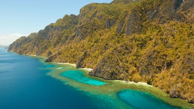 Aerial view: Lagoon with blue, azure water in the middle of small islands and rocks. Beach, tropical island, sea bay and lagoon, mountains with forest, Palawan, Coron. Busuanga. Seascape, tropical landscape. Philippines. Travel concept