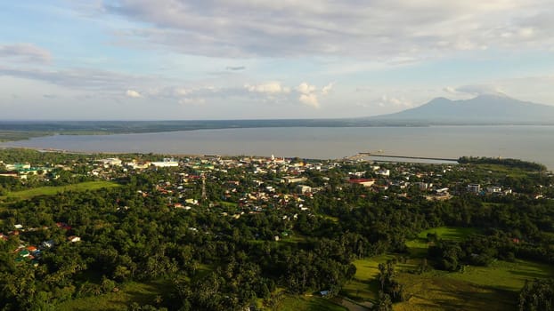 View of a small town and a volcano in the distance. Sorsogon City, Luzon, Philippines. Asian town by the sea, top view.