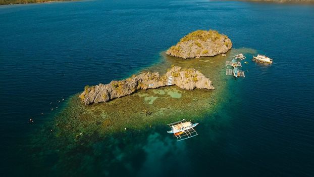 Aerial view: beach, tropical island, sea bay and lagoon, Palawan. Lagoon with blue, azure water in the middle of small islands and rocks. Busuanga. Seascape, tropical landscape. Philippines.