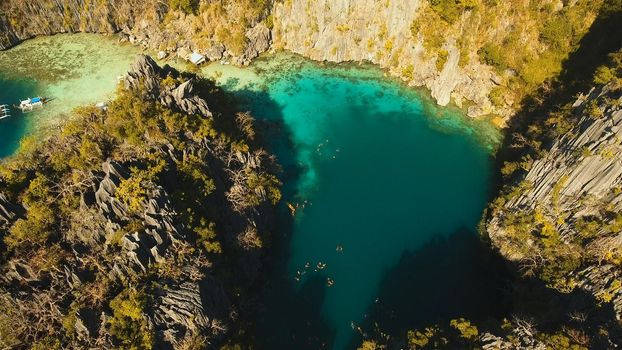 Aerial view: Twin Lagoon with blue, azure water in the middle of small islands and rocks. Beach, tropical island, sea bay and lagoon, mountains with forest, Palawan, Coron. Busuanga. Seascape, tropical landscape. Philippines. Travel concept