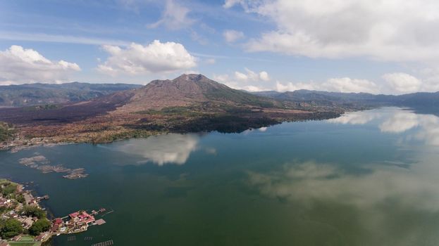 Aerial view Mountains, volcanoes, crater lake Batur, Bali, Indonesia. Mountain landscape with volcanoes, lake, sky and clouds. Travel concept