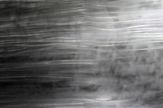 Close-up texture of flat steel surface manually cleaned with a flap wheel angle grinder. Surface prepaired before painting as part of the repair work.