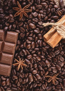 chocolate, coffee beans, anise on wooden background