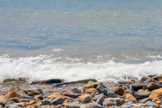 pebbles and stones on the beach. waves and splashes on the shore. High quality photo