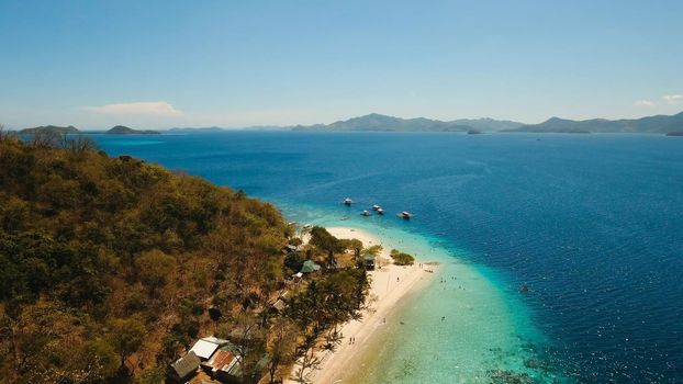 Aerial view of tropical beach on the island Banana, Philippines. Beautiful tropical island with sand beach, palm trees. Tropical landscape: beach with palm trees. Seascape: Ocean, sky, sea. Travel concept.