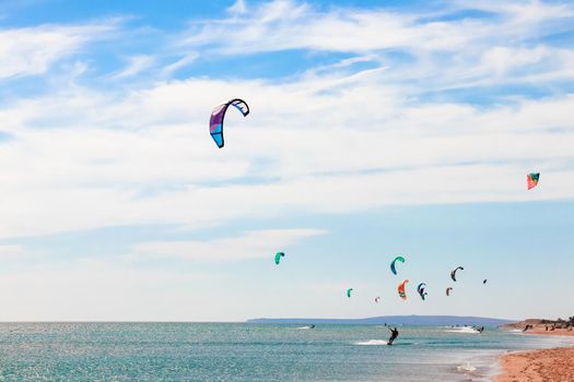 a kitesurfer surfing on the smooth azure water. recreational sport. A Man Rides A Kiteboarding In The Sea Water. extreme sport. High quality photo