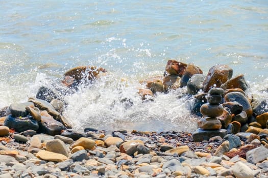 pebbles and stones on the beach. waves and splashes on the shore. High quality photo