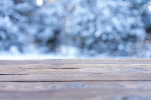 Beautiful winter scene. blurred background of snowy christmas nature background, Wood table top on shiny bokeh. For product display Christmas time mock up