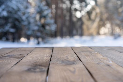 Beautiful winter scene. blurred background of snowy christmas nature background, Wood table top on shiny bokeh. For product display Christmas time mock up