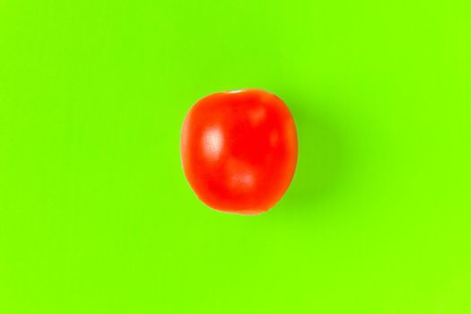 red tomato on a green background. hard shadow. isolate. High quality photo