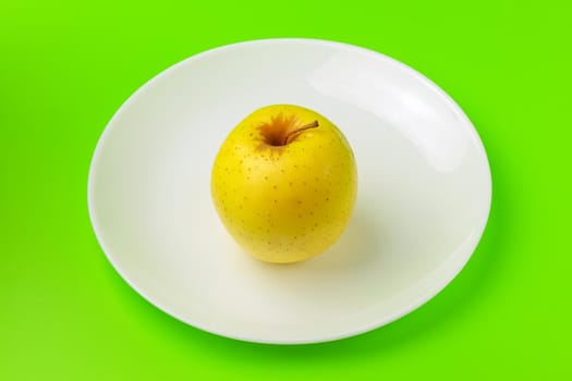 yellow Apple on a green background close-up.isolate. High quality photo