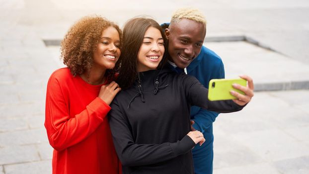 Multi ethnic friends outdoor taking a selfie on smartphone. Diverse group people Afro american asian spending time together Multiracial male female student meeting outdoors