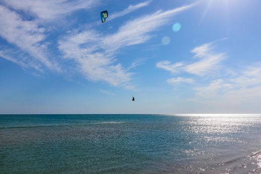 a kitesurfer surfing on the smooth azure water. recreational sport. A Man Rides A Kiteboarding In The Sea Water. extreme sport. High quality photo