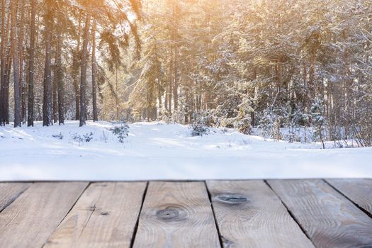 Beautiful winter scene. blurred background of snowy christmas nature background, Wood table top on shiny bokeh. For product display Christmas time mock up