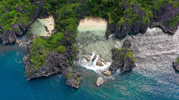 Sandy beach with tourists and tropical island by atoll with coral reef, top view. Lahos Island, Caramoan Islands, Philippines. Summer and travel vacation concept.