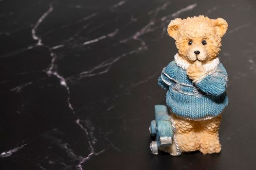 toy bear statue on black marble. copy space. High quality photo