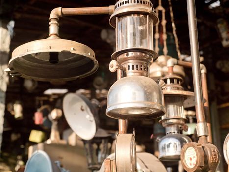An old, vintage lamp with a shade in an antique store. Antiquarian shop with old ancient lamps. Antique street shop in Bali.