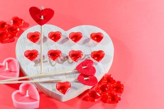 pink candles in the form of a heart on a red background for Valentine's day . High quality photo