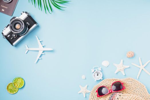 Flat lay top view mockup retro camera films, airplane, starfish, shells, hat traveler tropical accessories on a blue background with copy space, Business trip, and vacation summer travel concept