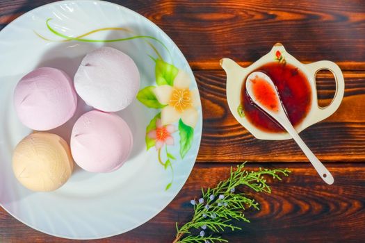 colorful marshmallows on a plate on a wooden background. High quality photo