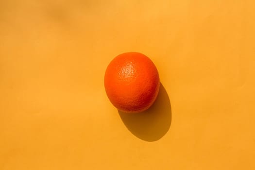orange on a yellow background. hard shadow. isolate. High quality photo