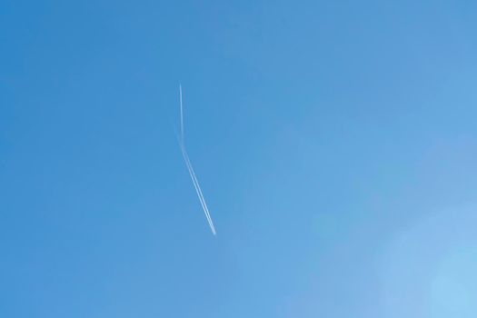 the plane and its footprint in the blue sky. High quality photo